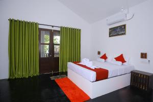 a bedroom with a bed with green curtains at Rekawa Lagoon Resort in Tangalle