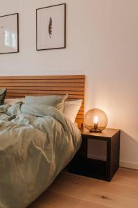 a bedroom with a bed and a side table with a lamp at Luxury 2BR Apartment in Haapsalu Old Town in Haapsalu
