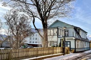 a white house with a fence and a tree at Luxury 2BR Apartment in Haapsalu Old Town in Haapsalu