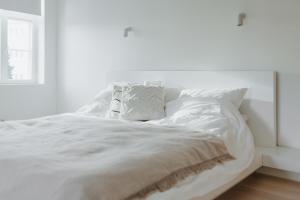 a white bed with white sheets and a window at Luxury 2BR Apartment in Haapsalu Old Town in Haapsalu
