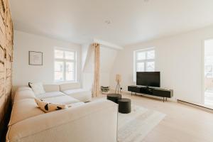 a white living room with a couch and a tv at Luxury 2BR Apartment in Haapsalu Old Town in Haapsalu