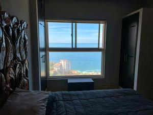 ein Schlafzimmer mit einem Bett und einem großen Fenster in der Unterkunft Conchas chinas sunset view in Puerto Vallarta