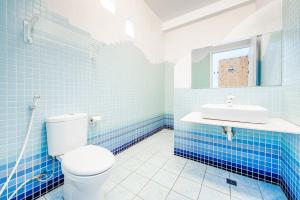 a blue tiled bathroom with a toilet and a sink at White Lighthouse in Xiaoliuqiu