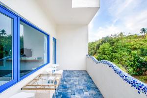 a room with a balcony with a view of the ocean at White Lighthouse in Xiaoliuqiu