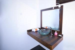 a bathroom vanity with a mirror and a sink at Rekawa Lagoon Resort in Tangalle