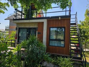 una casa con una escalera que conduce a ella en ไร่ปาริชาติ, en Ban Khanong Phra Tai