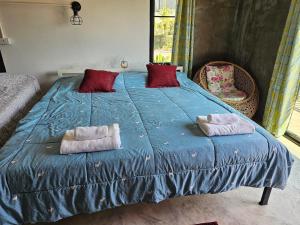 a large blue bed with two pillows on it at Parichat house ไร่ปาริชาติ in Ban Khanong Phra Tai