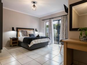 1 dormitorio con cama y ventana grande en Magnolia Guesthouse en Alberton