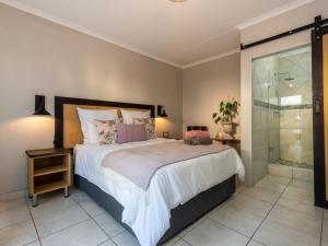 艾伯頓的住宿－Magnolia Guesthouse，一间卧室设有一张大床和玻璃淋浴间