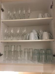a bunch of wine glasses and dishes on shelves at Lovely Downtown House +2 parking in Toronto
