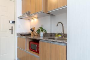 a kitchen with a sink and a microwave at 732 Express Condotel, 3 Minutes to Airport, FAST WI-FI, Free Netflix in Pusok