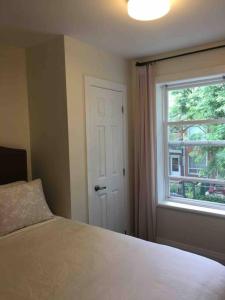 - une chambre avec un lit et une fenêtre dans l'établissement Lovely Downtown House +2 parking, à Toronto