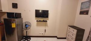a room with a refrigerator and a tv on the wall at MS PASAY HOMESTAY 101 NEWPORT BLVD - Airport NAIA T3 near SAVOY BELMONT 300MBPS NETFLIX in Manila