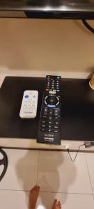 a remote control sitting on top of a table at MS PASAY HOMESTAY 101 NEWPORT BLVD - Airport NAIA T3 near SAVOY BELMONT 300MBPS NETFLIX in Manila