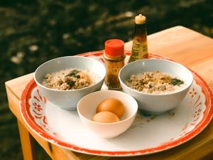 a tray with three bowls of food and two bottles of beer at Mon Jaw Doi at Monjam in Chiang Mai