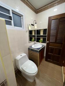 a bathroom with a toilet and a sink and a window at New Home Yบ้านเดี่ยวสร้างใหม่ ใกล้ทะเล ใจกลางเมืองระยอง in Ban Chak Phai