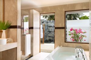 a bathroom with a tub and a window at Kurumba Maldives in Male City