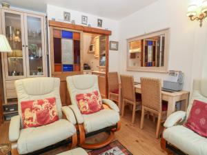 a living room with chairs and a table and a dining room at Beech Apartment in Cheltenham