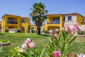 a yellow house with a palm tree and flowers at Case Gialle in San Teodoro