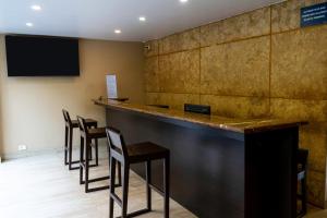 a bar with chairs and a television on a wall at Sia Signature Calangute in Calangute