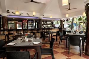 a restaurant with tables and chairs and a bar at Lucianas Beach Resort in Marmagao