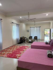 a bedroom with two beds and a rug at Akram Homestay in Kota Bharu