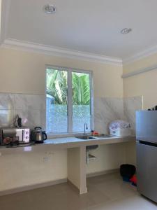 cocina con fregadero y ventana en Akram Homestay, en Kota Bharu