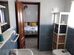 La salle de bains est pourvue d'un lavabo, de toilettes et d'un lit. dans l'établissement B&B Casa Sarandy, à Almogía