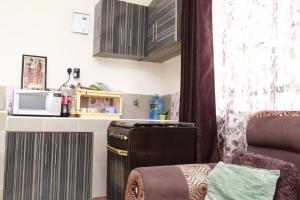 a small kitchen with a microwave and a stove at Zanale Stays Furnished Apartment? in Nairobi