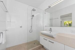 a white bathroom with a sink and a shower at 6 The Landing in Noosaville +11 photos