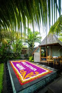 a carpet of flowers on the ground in front of a house at Lasamana Villas Ubud by Pramana Villas in Ubud