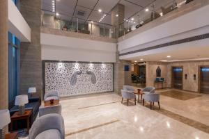 a lobby with chairs and a table in a building at ExpoInn Suites and Convention in Greater Noida