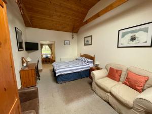 a living room with a bed and a couch at The Waterings in St. Davids