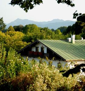 une maison noire et blanche avec un toit vert dans l'établissement Hotel Alter Wirt, à Weyarn