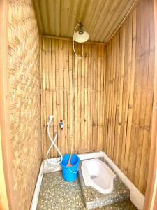 a bathroom with a toilet in a wooden wall at Saung Arjuna Syandana Resort in Ciwidey