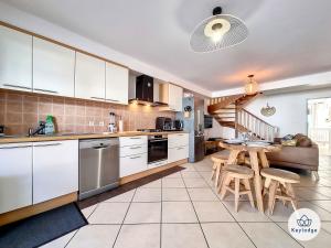 a kitchen with white cabinets and a table at Leu Bengali - 3 étoiles - T4 duplex à Saint-Leu in Saint-Leu