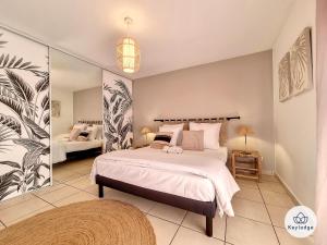 a bedroom with a large bed and a mirror at Leu Bengali - 3 étoiles - T4 duplex à Saint-Leu in Saint-Leu