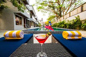 a drink sitting on a table next to a pool at Meritas Aura Resort in Lonavala