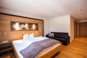 sypialnia z dużym łóżkiem i kanapą w obiekcie Posthotel Pfunds w mieście Pfunds