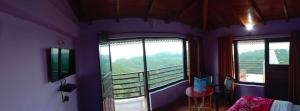 Habitación con balcón con vistas a la montaña. en Lord Krishna Himalayan Hotel & Restaurant, en Mukteshwar