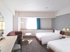 una camera d'albergo con 2 letti e una scrivania di Chisun Hotel Yokohama Isezakicho a Yokohama