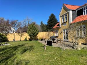 una casa con patio y mesa de picnic en Bjergly, en Hjørring