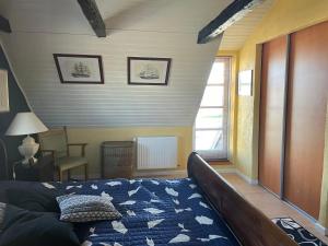 ein Schlafzimmer mit einem Bett, einem Stuhl und einem Fenster in der Unterkunft Bjergly in Hjørring