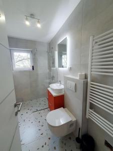 y baño con aseo blanco y lavamanos. en StudioApartman M en Valpovo