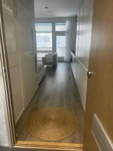 a hallway with a room with a chair and a rug at Yksiö loistavalla sijainnilla sekä yhteyksillä in Vantaa