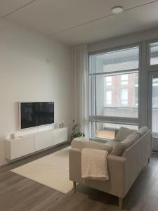 uma sala de estar com um sofá e uma televisão de ecrã plano em Yksiö loistavalla sijainnilla sekä yhteyksillä em Vantaa