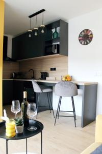 eine Küche mit schwarzen Schränken und einem Tisch mit Weingläsern in der Unterkunft StudioApartman M in Valpovo