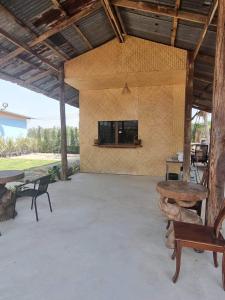 Ban Rai Khlong Sai的住宿－แกนล่อน เฮ้าส์，一个带桌子的庭院和墙上的电视