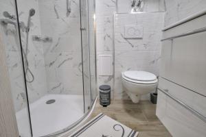 La salle de bains blanche est pourvue d'une douche et de toilettes. dans l'établissement Studio Pika, à Kranjska Gora