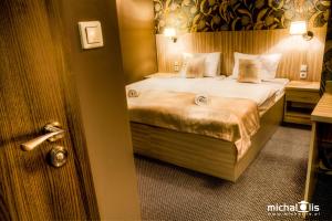 um quarto de hotel com uma cama com lençóis brancos e almofadas em Aviator em Pabianice